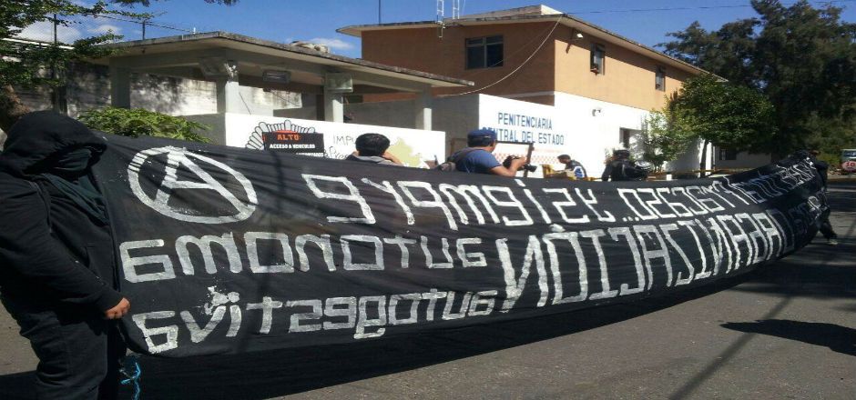 Encapuchados marchan y realizan pintas por caso Ayotzinapa en Oaxaca