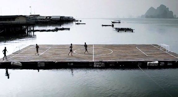 Niños tailandeses juegan futbol sobre el agua