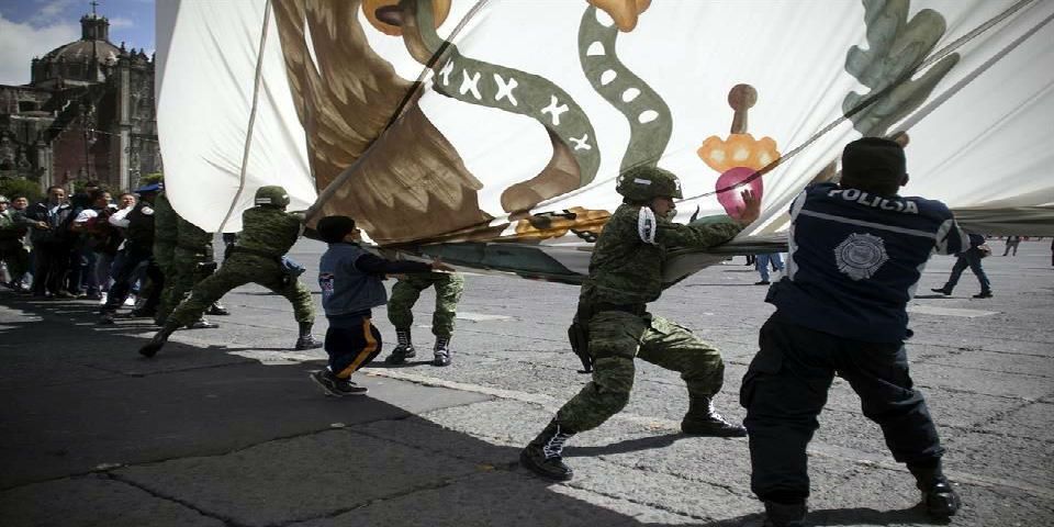 Civiles ayudan a militares a arriar la bandera del Zócalo
