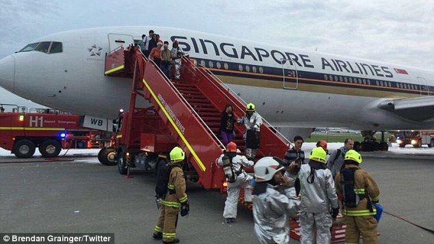Vuelo de Singapore Airlines se incendia tras aterrizaje de emergencia - pasajeros-bajando-avion-fuego