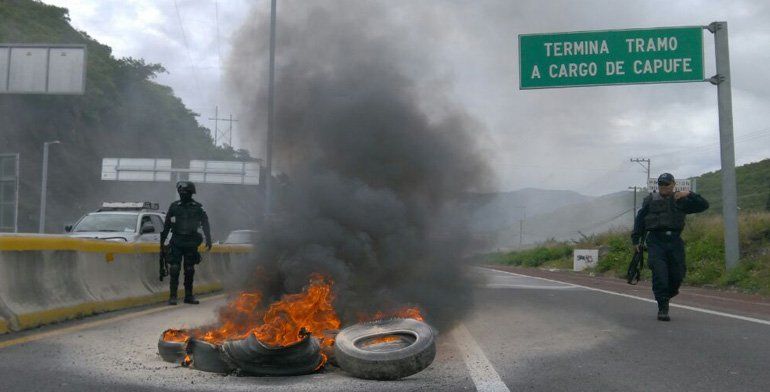 Normalistas queman llantas en Autopista del Sol
