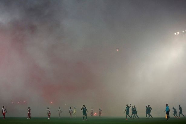 Suspenden futbol en Grecia tras hechos de violencia - Olympiakos-and-Panathinaikos-players-walking-amidst-smoke-from-flares-lit-up-by-fans