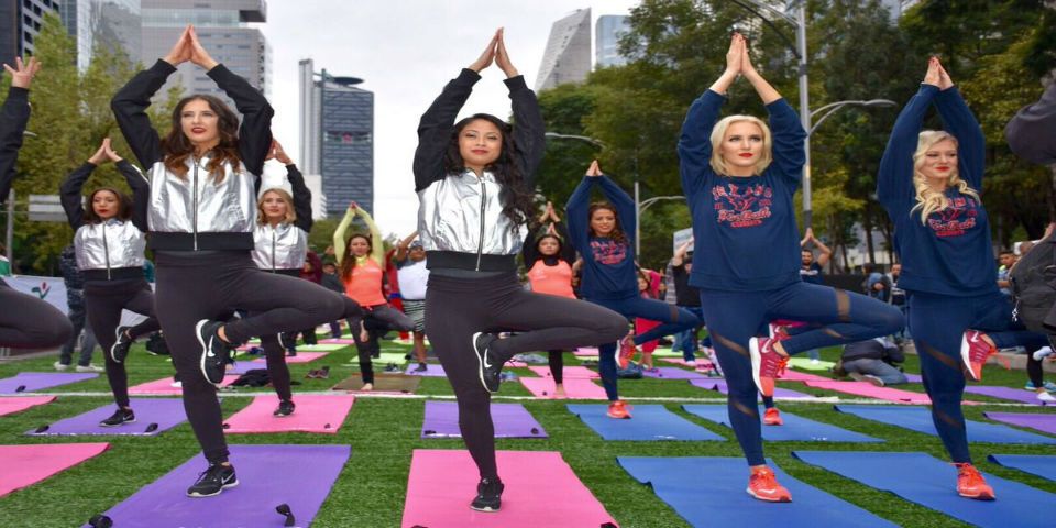 Porristas de Raiders y Texans realizan yoga en el Ángel de lndependencia