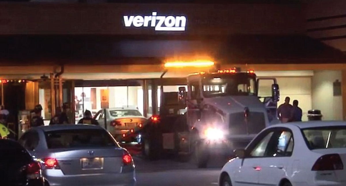 Hombre conduce su automóvil al interior de una tienda de telefonía Hombre conduce su automóvil al interior de una tienda de telefonía
