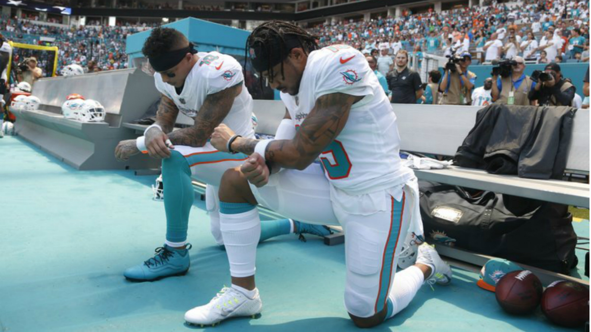 Jugadores de Delfines de Miami se arrodillan durante el himno nacional