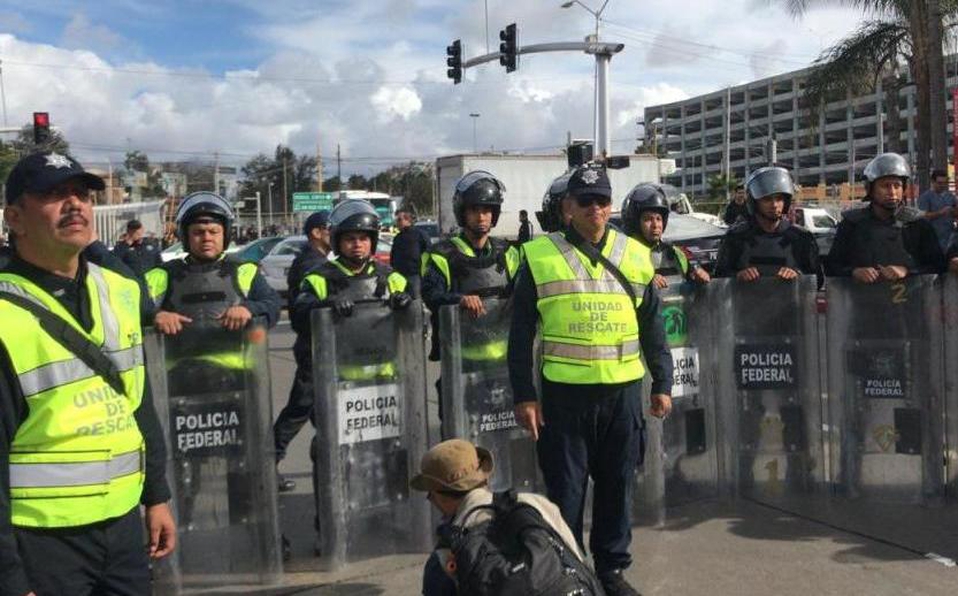 Migrantes avanzan rumbo a puente fronterizo en Tijuana - valla-policial-puente-fronterizo