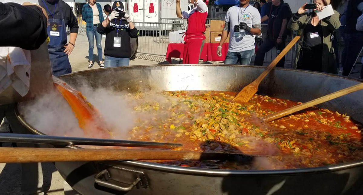 Chefs internacionales deleitan a migrantes con paella