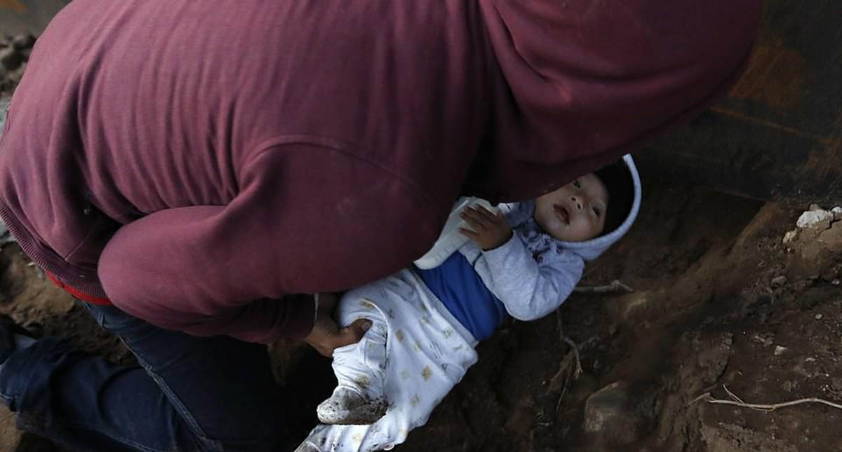 Migrante pasa a su bebé por un túnel hacia EE.UU.