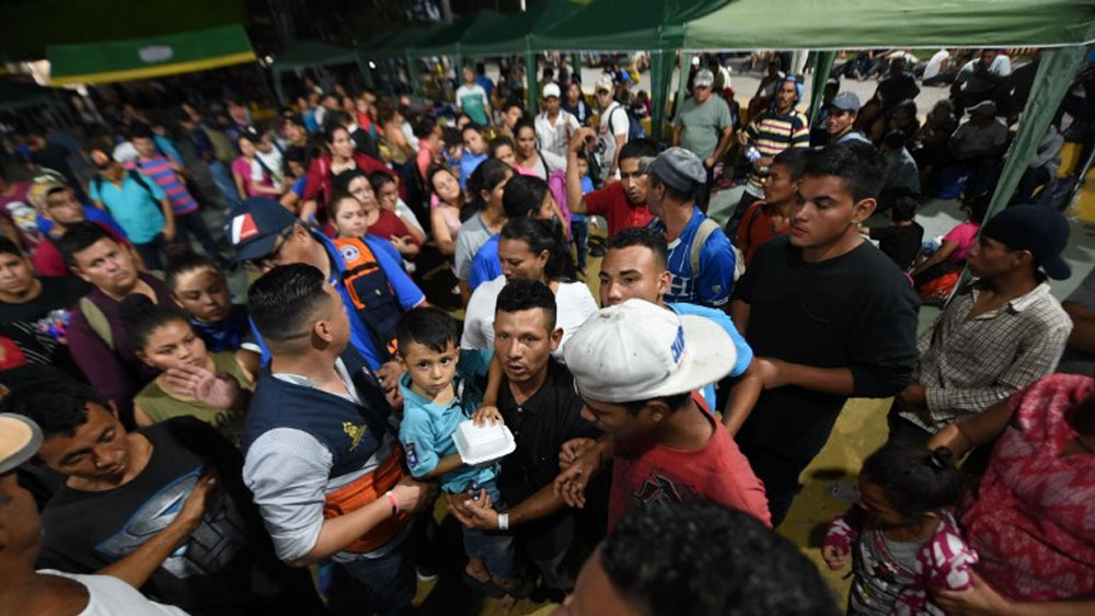 Caravana migrante rompe portón en frontera y cruza hacia México