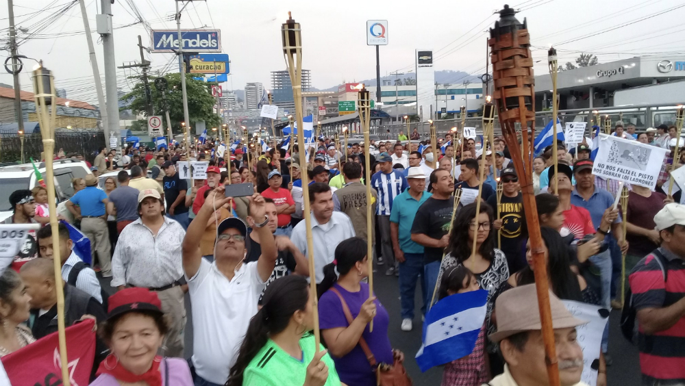 Miles de hondureños marchan con antorchas pidiendo salida del presidente