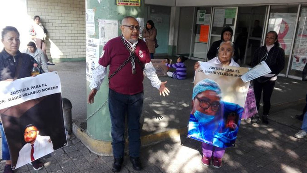 Padre de médico muerto se encadena a hospital para exigir justicia
