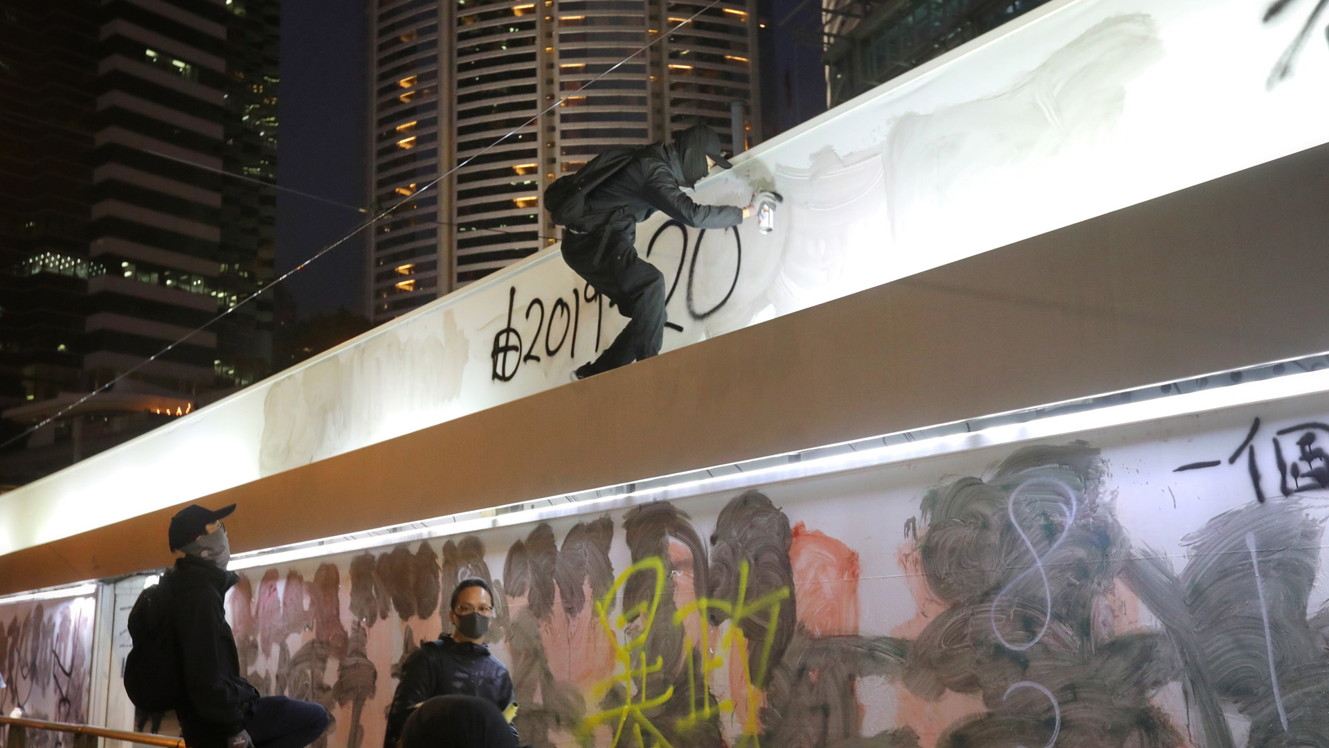 Hongkoneses vuelven a tomar las calles en Año Nuevo por protesta - activista-prodemocratico-pinta-grafiti-durante-protesta-contra-el-gobierno-de-hong-kong
