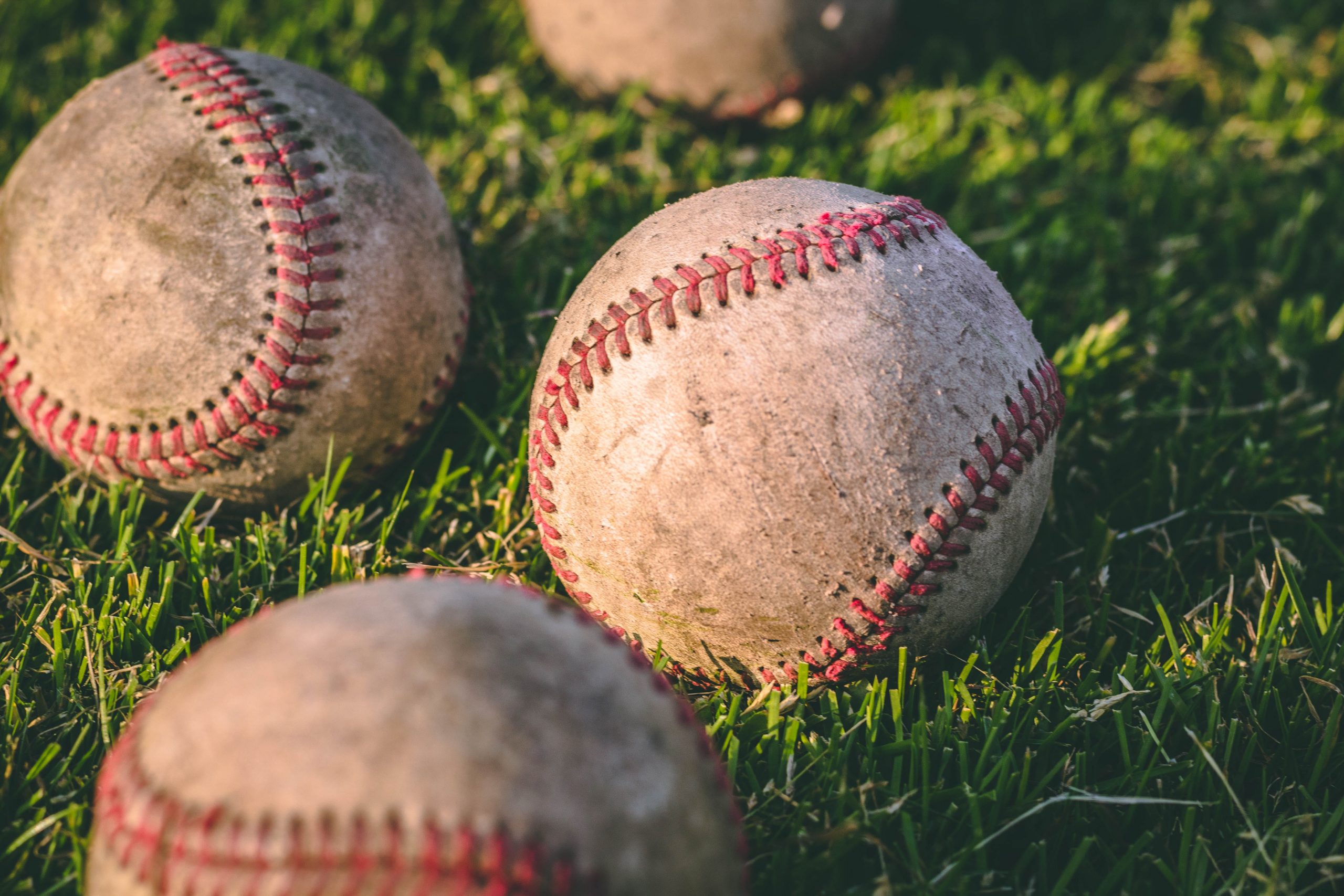 Las Grandes Ligas quieren que más gente siga el beisbol en México - close-up-photography-of-four-baseballs-on-green-lawn-grasses-1308713-scaled