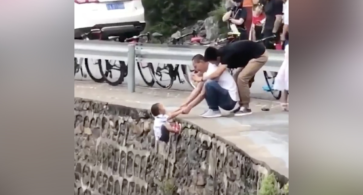 #Video Hombre sujeta a niño sobre un acantilado solo para tomarle una foto