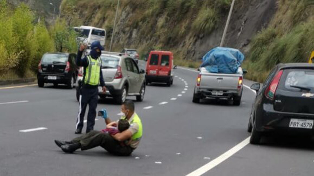 Policía consuela a niño a mitad de la carretera en accidente vial