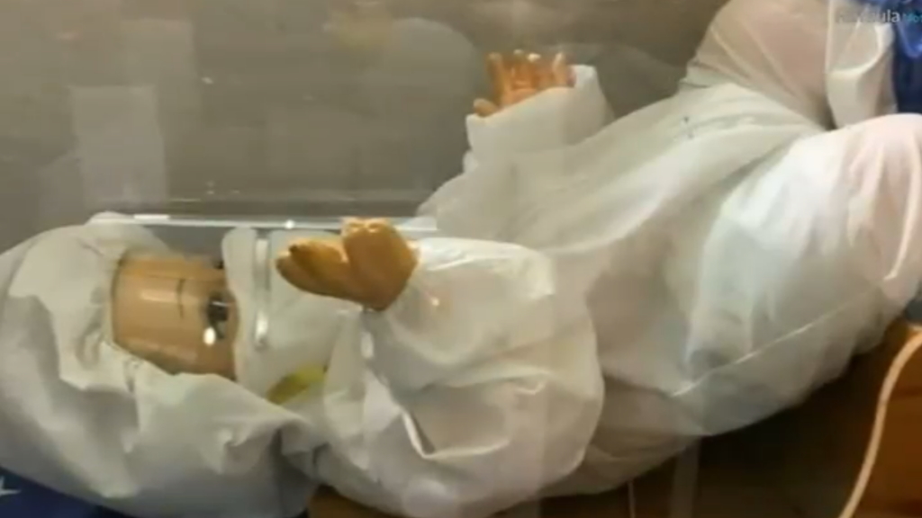 Niño Dios con equipo de protección para COVID-19 da aliento a pacientes y médicos