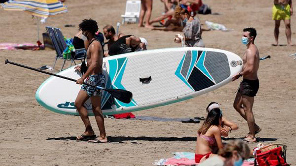 Proyecta IHME casi 139 mil muertes por COVID-19 en México para fin de año - jovenes-espanoles-con-cubrebocas-disfrutan-la-reapertura-de-la-playa-malverrosa-en-valencia