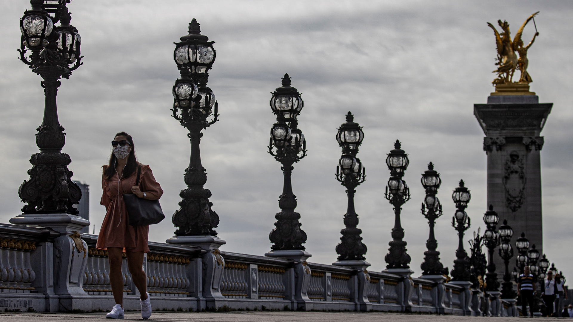 Suma Francia 30 mil 701 decesos por COVID-19; detectan 58 nuevos focos de contagio - mujer-con-cubrebocas-camina-sobre-el-puente-alejandro-iii-en-paris