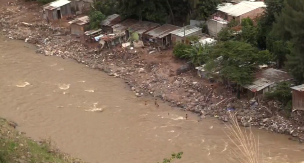 Niños hondureños víctimas de Eta e Iota se bañan en pestilentes aguas estancadas