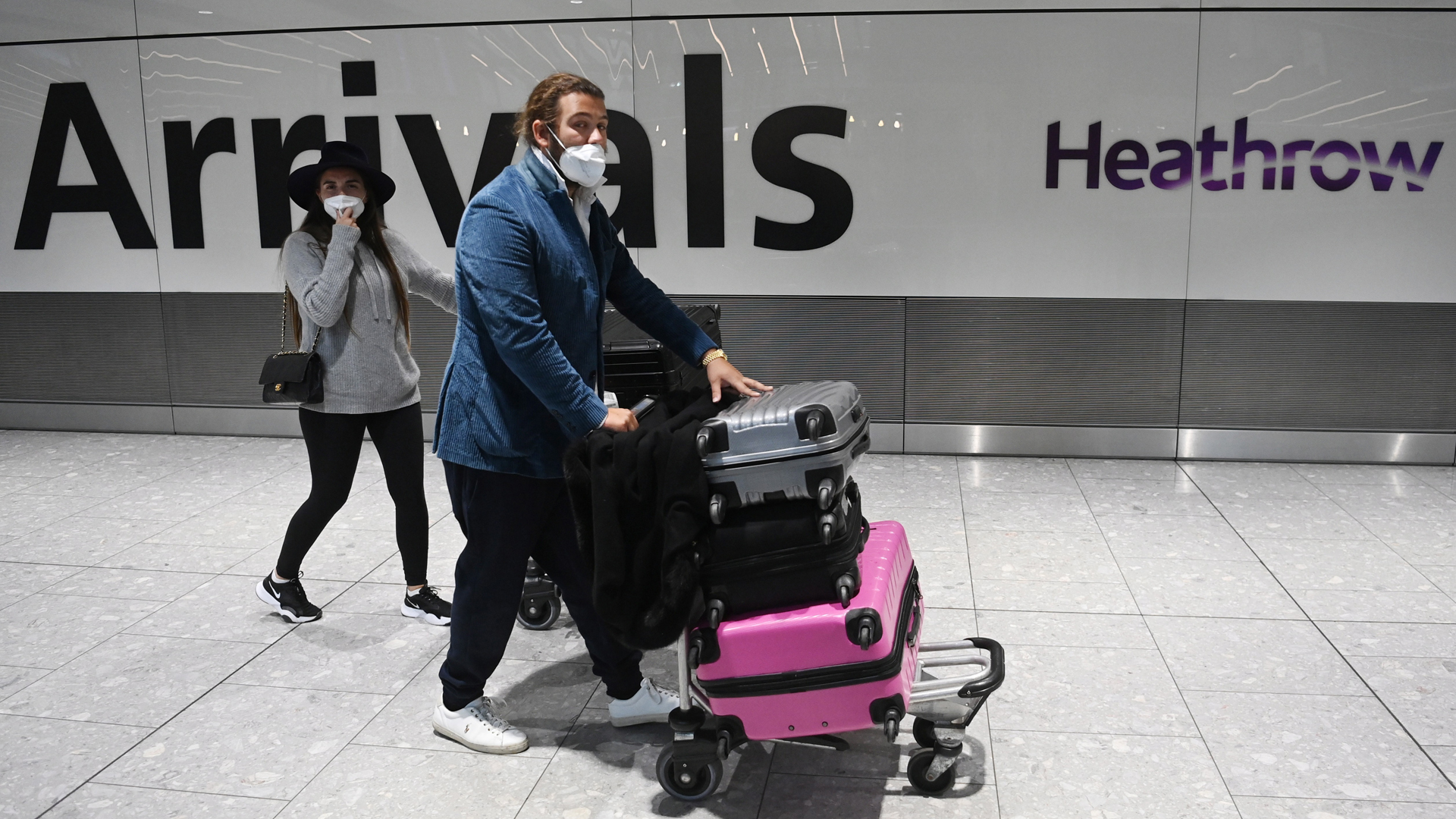 Reino Unido suspende corredores aéreos para evitar cepas importadas de COVID-19 - turistas-en-zona-de-llegadas-de-aeropuerto-de-reino-unido