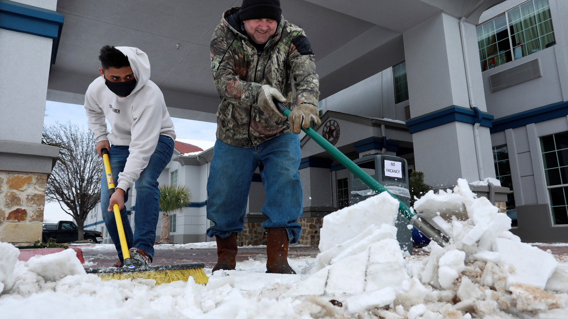 Joe Biden dispuesto a viajar a Texas, en emergencia por bajas temperaturas - empleados-remueven-capas-de-nieve-afuera-de-hotel-en-texas