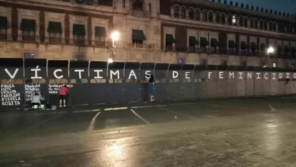 Mujeres graban en las vallas de Palacio Nacional los nombres de víctimas de feminicidio