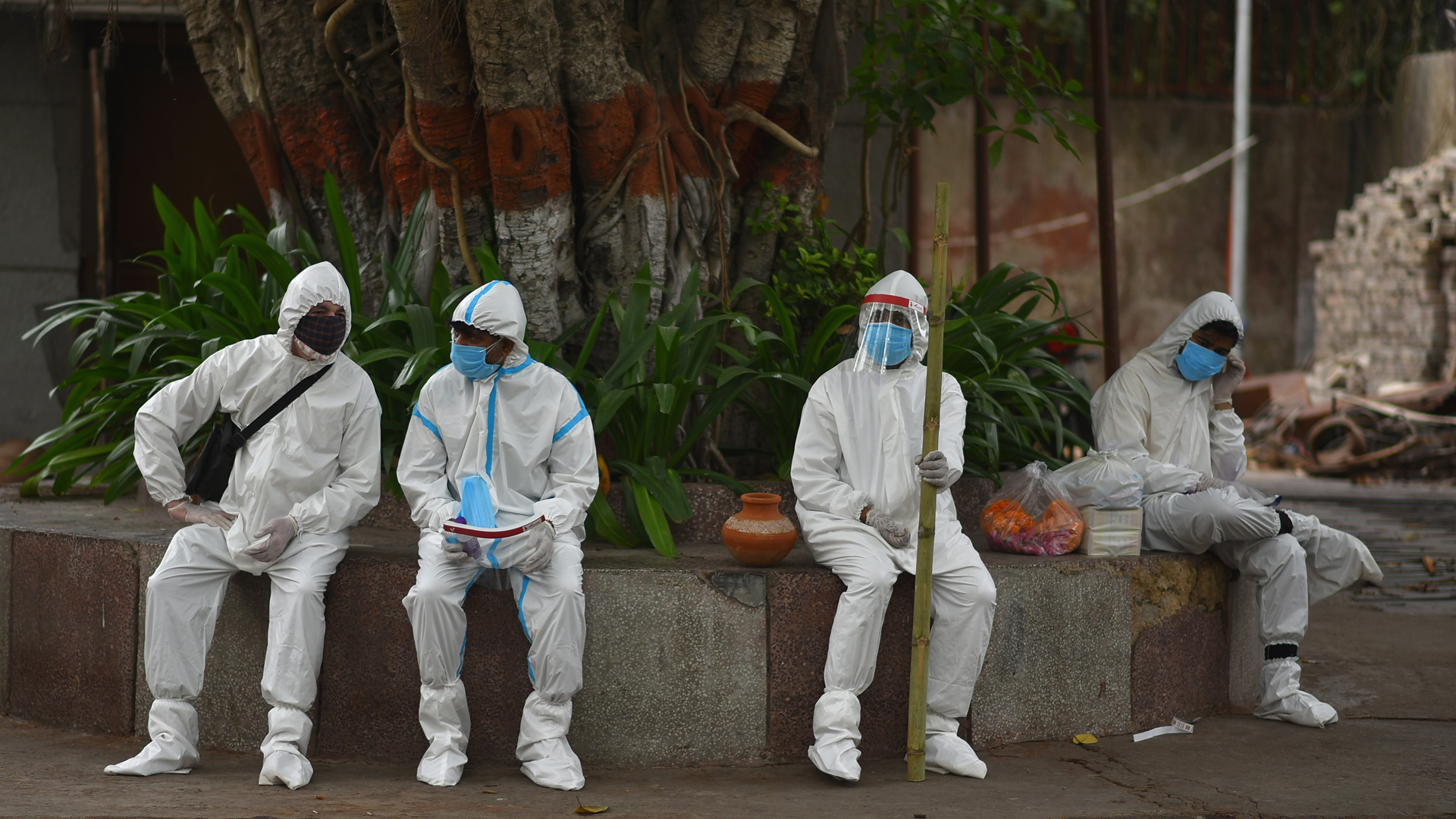 India suma menos de 300 mil casos de COVID-19 por primera vez en 25 días - familiares-de-victima-de-covid-19-con-trajes-sanitarios-previo-a-funeral