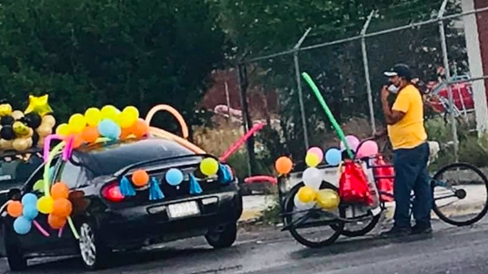 Hombre lleva a sus hijos a caravana de fin de cursos en triciclo