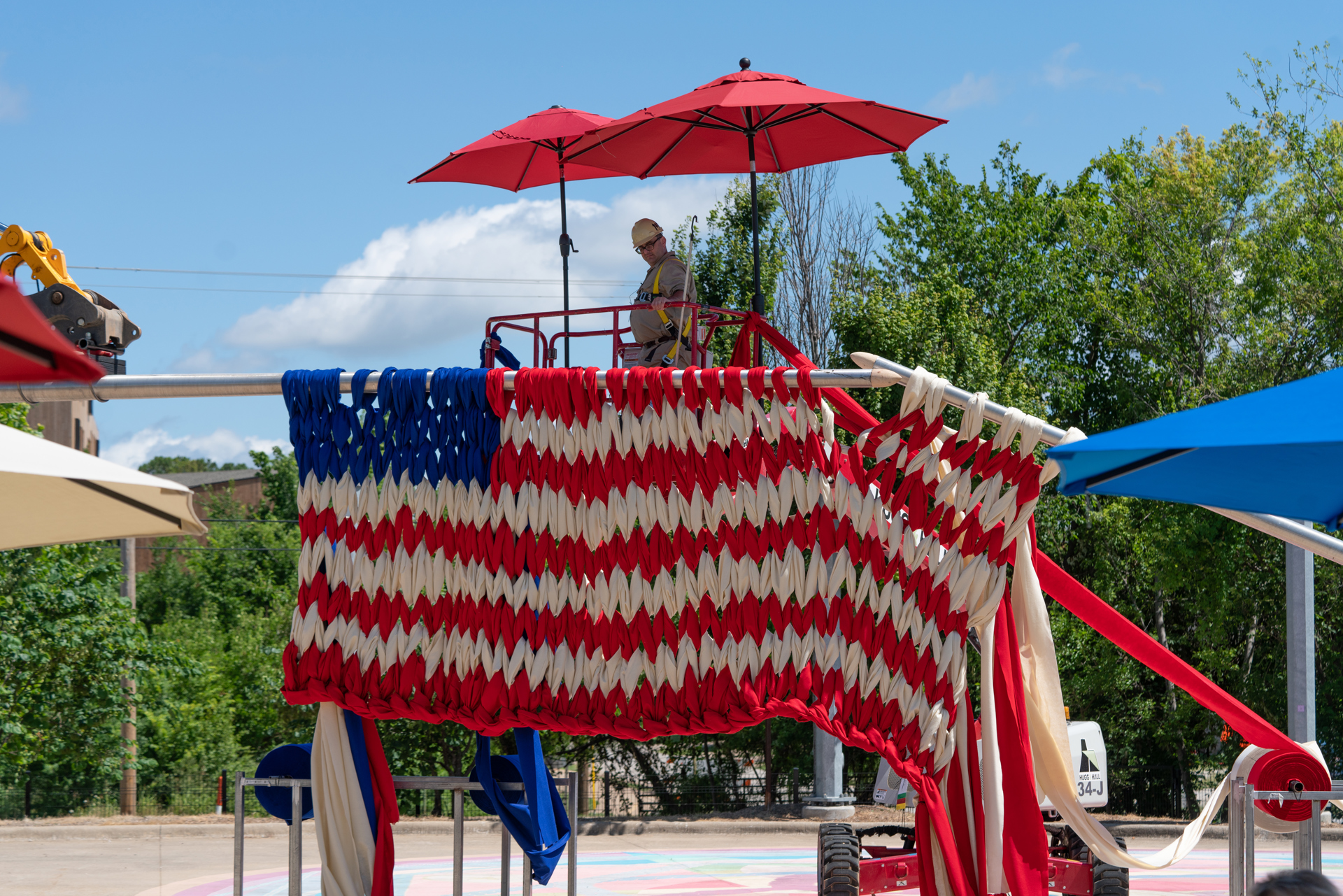 Una enorme bandera tejida con postes telefónicos como agujas se exhibe en EE.UU.