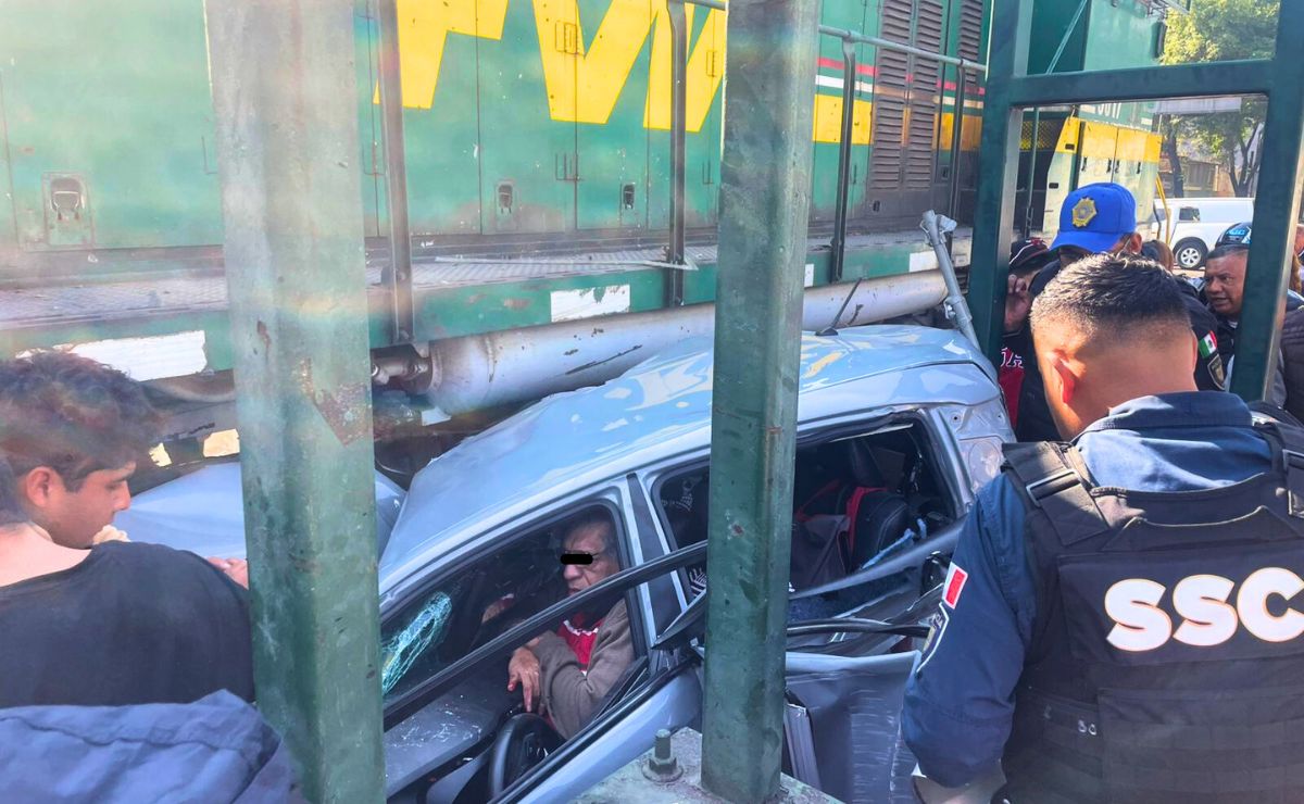 Tren arrolla vehículo en la Cuauhtémoc; adulto mayor queda prensado